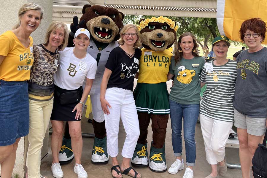 Seven Baylor alumni posing with Bruiser and Marigold mascots at a Dr Pepper Hour Tour event in Phoenix, all wearing Baylor green and gold gear