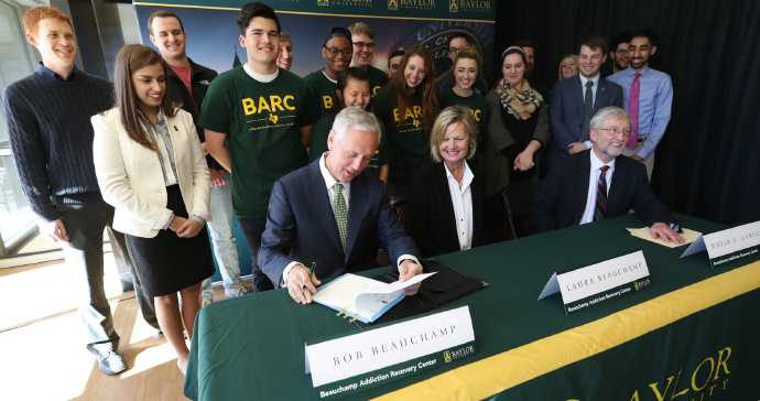 Bob and Laura Beauchamp with Interim President David E. Garland sign the gift agreement to establish the Beauchamp Addiction Recovery Center at Baylor
