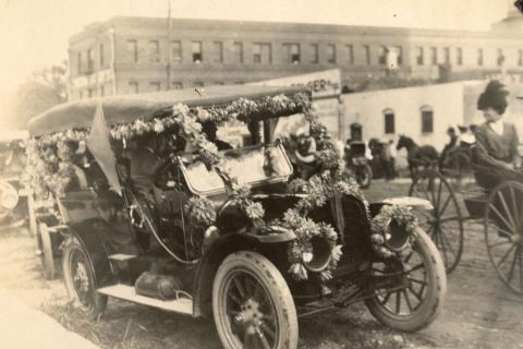 Vintage photo of an early automobile decorated with flowers for the Homecoming parade.