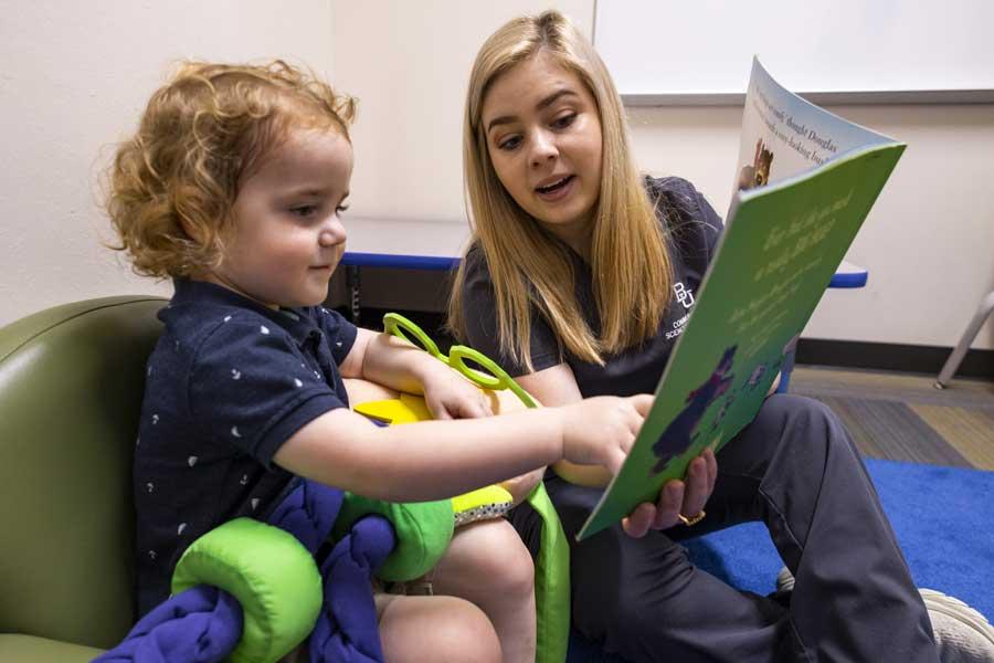 Student reading to client in The Mary Jo Robbins Clinic for Autism Research and Practice