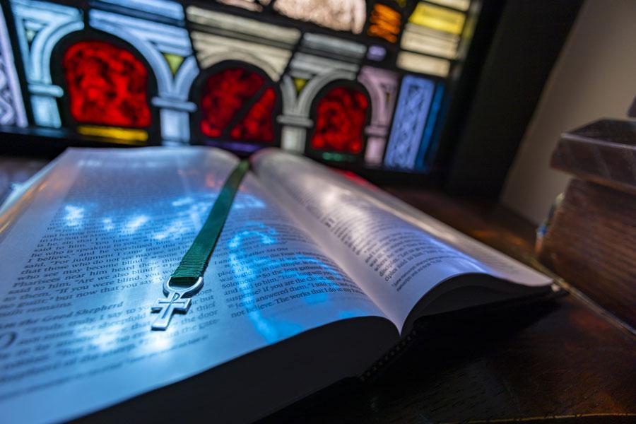 Bible open in front of a stained glass window