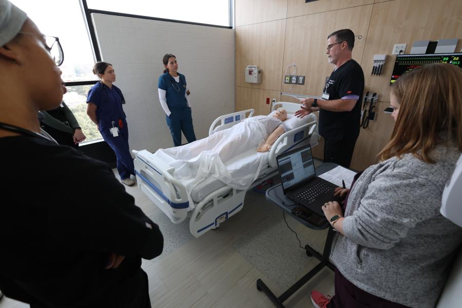 Students learning in the simulation lab with professor.